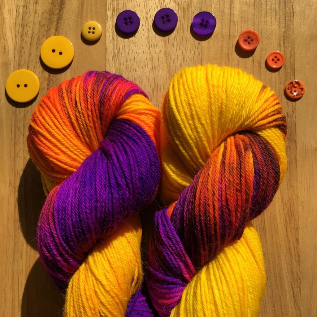 hand-dyed-purple-orange-and-yellow-wool-with-arc-of-matching-buttons-above-it.