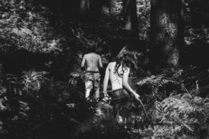 topless-children-walking-through-woods-in-black-and-white.